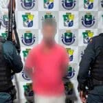 Foto de homem sendo detido por dois policiais militares no bairro Loiola, Lagarto, em cumprimento de mandado de prisão por roubo.