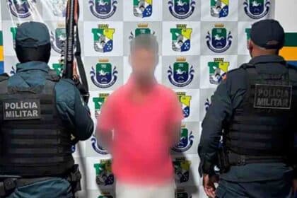 Foto de homem sendo detido por dois policiais militares no bairro Loiola, Lagarto, em cumprimento de mandado de prisão por roubo.