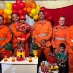 Criança vestida de bombeiro ao lado de militares do Corpo de Bombeiros em Lagarto.