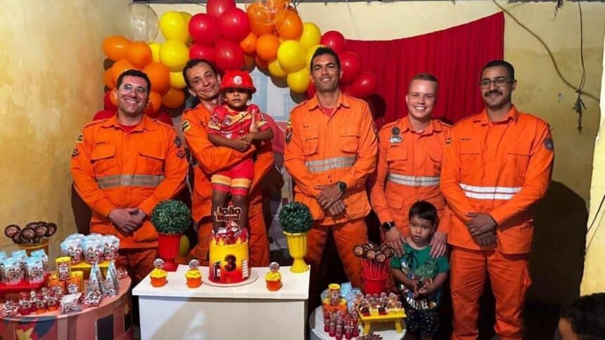 Criança vestida de bombeiro ao lado de militares do Corpo de Bombeiros em Lagarto.
