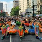 Grupo cultural dos Parafusos de Lagarto se apresentando para uma multidão na Avenida Paulista durante a Virada Cultural.