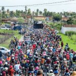 pessoas acompanhando a pega do mastro