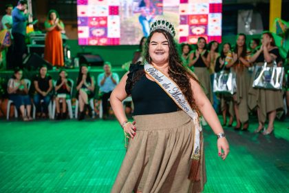 A jovem Laís Sandy sorridente, coroada e com a faixa de XII Rainha da Mandioca de Lagarto, celebrando a vitória no palco da Vila da Capital Nacional da Vaquejada.