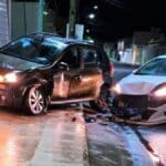 Veículo com a parte frontal danificada encostado no portão de uma residência após colisão no Centro de Lagarto.