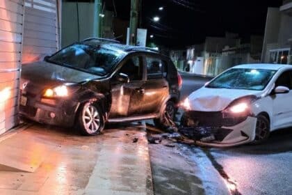 Veículo com a parte frontal danificada encostado no portão de uma residência após colisão no Centro de Lagarto.