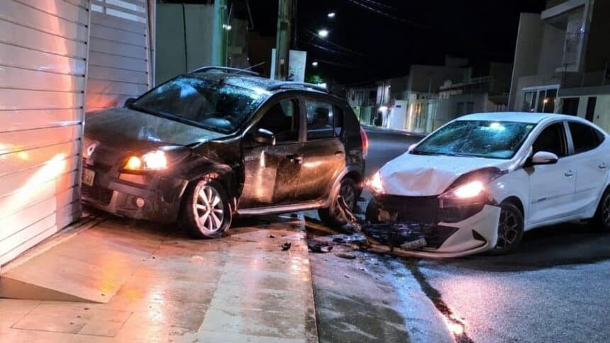 Veículo com a parte frontal danificada encostado no portão de uma residência após colisão no Centro de Lagarto.