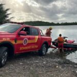 Viatura de resgate e salvamento do Corpo de Bombeiros estacionada às margens de área ribeirinha durante buscas por adolescente desaparecido no Rio do Sal.