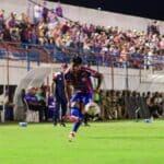 Vista aérea do estádio Etelvino Mendonça lotado, mostrando o gramado verde e as arquibancadas pintadas nas cores azul e vermelho.