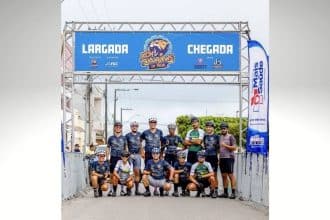Atletas da equipe Lagartos Race Team reunidos no pódio, segurando troféus e medalhas de ouro, vestindo o uniforme oficial de ciclismo.