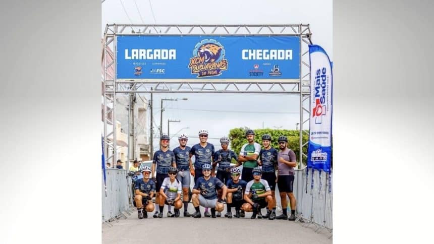 Atletas da equipe Lagartos Race Team reunidos no pódio, segurando troféus e medalhas de ouro, vestindo o uniforme oficial de ciclismo.