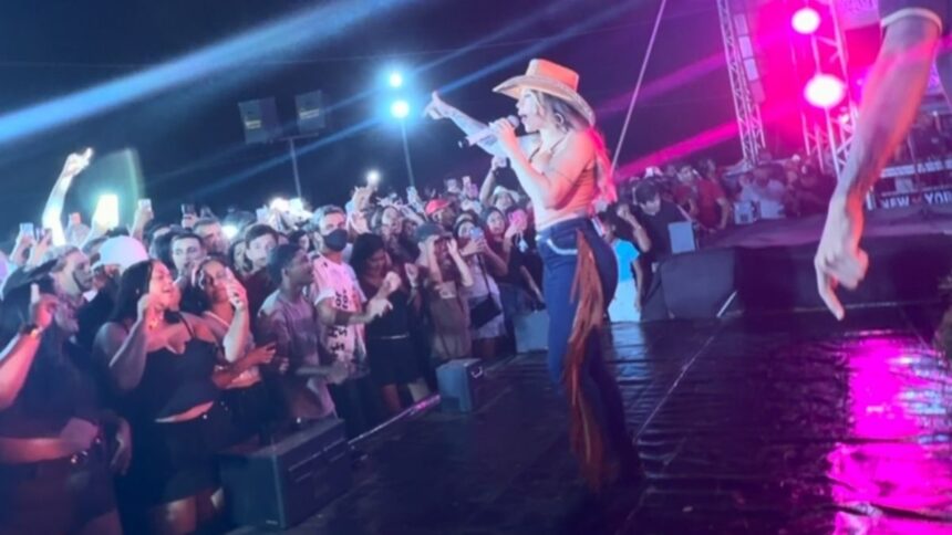 Cantora Liene Show protestando no palco durante evento em Telha