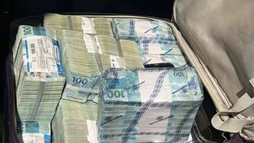 Viatura da polícia e notas de dinheiro apreendidas na operação conjunta.