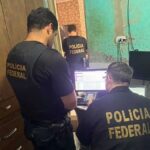 Agente da Polícia Federal segurando material apreendido em operação.