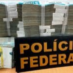 Agentes da Polícia Federal exibindo montante em cédulas apreendidas.